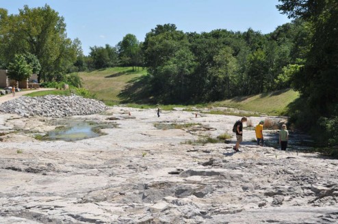 A view of Devonian Fossil Gorge, complete with interested visitors and constructed walkway