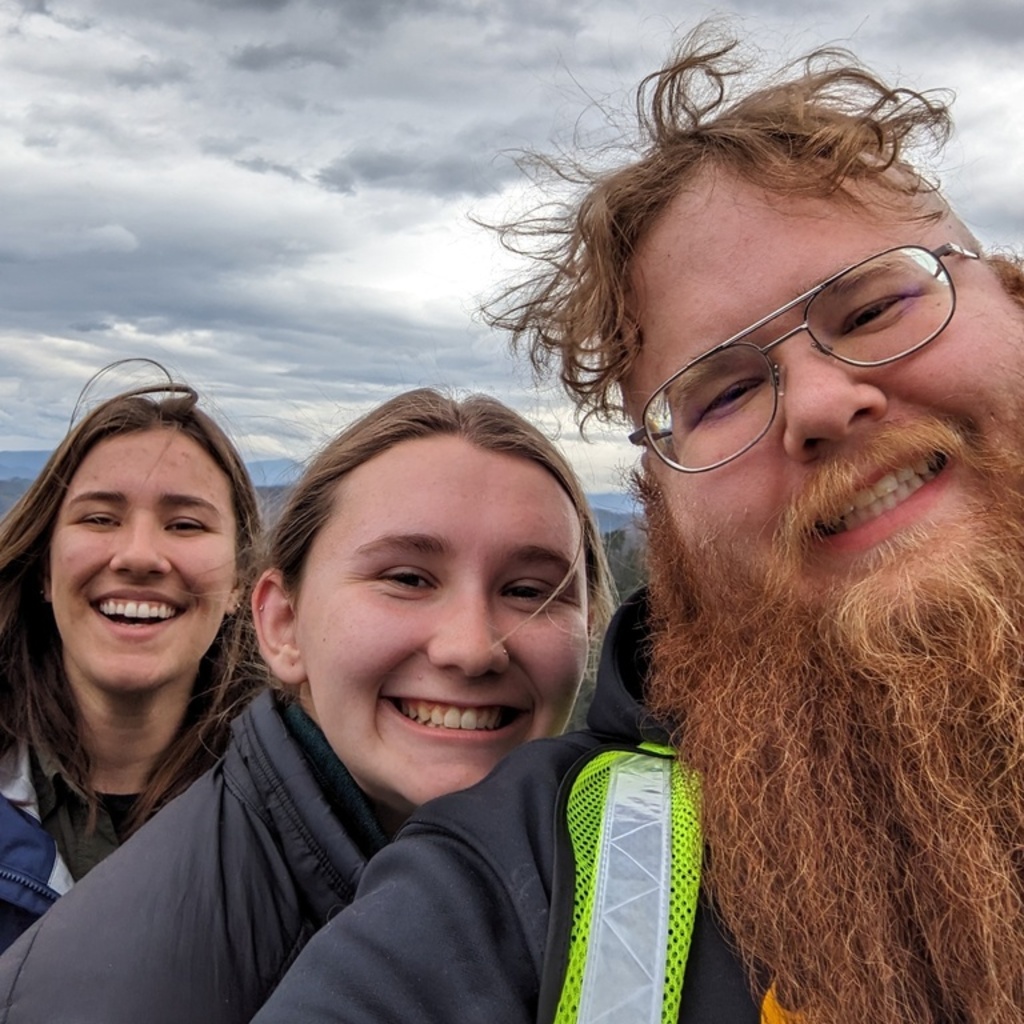 Trent Olson smiles with two other people outside