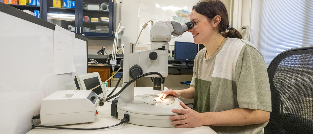 EES student at a microscope conducting research